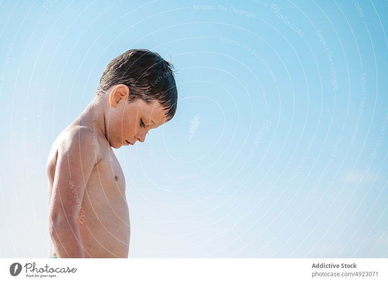 Trauriger Junge steht im Sommer am Strand Kind traurig unglücklich MEER Küste Ufer verärgert unzufrieden Unmut Unzufriedenheit Problematik tropisch Ärger