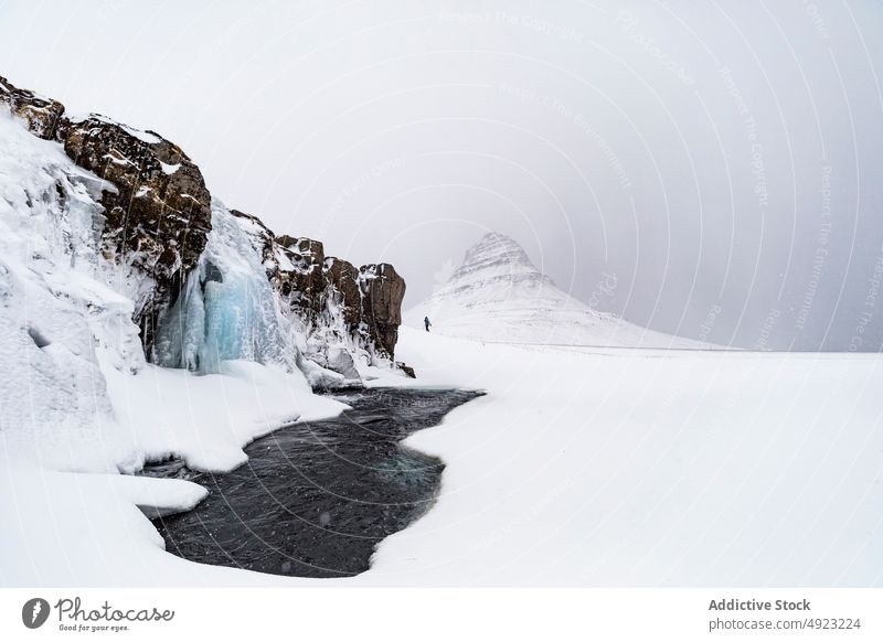 Reisen in Seenähe in bergigem Terrain im Winter Schnee Reisender Landschaft Eis erkunden Tourismus gefroren Winterzeit Gelände Hochland Island Himmel ruhig