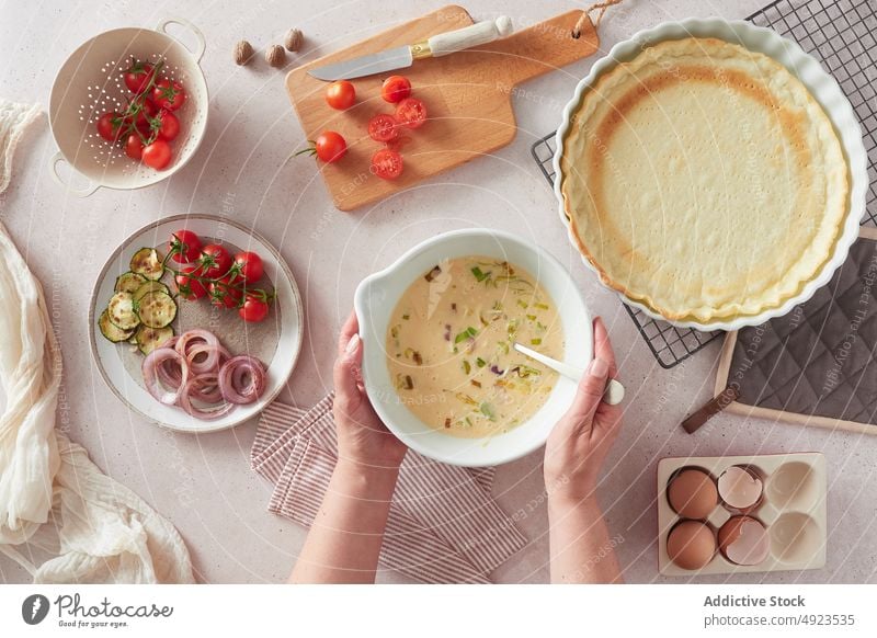 Eine Frau bereitet die Füllung für eine Quiche vor Brotbelag Kruste Koch Tisch Küche Gemüse melken Rezept natürlich heimisch führen Schalen & Schüsseln