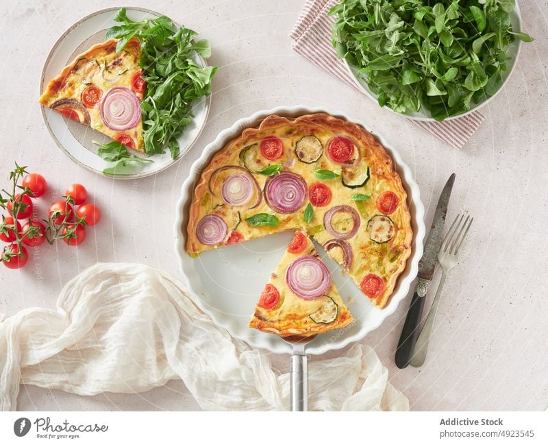 Anonyme Person nimmt ein Stück Quiche Backblech Speise Mittagessen Spachtel frisch Spielfigur heimwärts Gemüse Lebensmittel Küche Scheibe Zwiebel Tomate