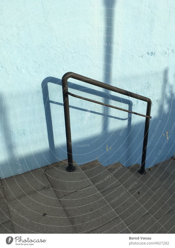 Nach unten – Abstiegshilfe aus Metallrohr Treppe Geländer Schatten Betonwand blau Metallgeländer Kontrast Treppengeländer Menschenleer Licht abwärts