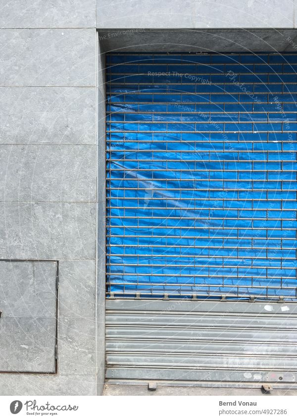 Geschlossener Laden mit trister Fassade Leerstand Ladengeschäft blau grau Fliesen u. Kacheln Wand Menschenleer Haus Gebäude Außenaufnahme Mauer Stadt Gitter