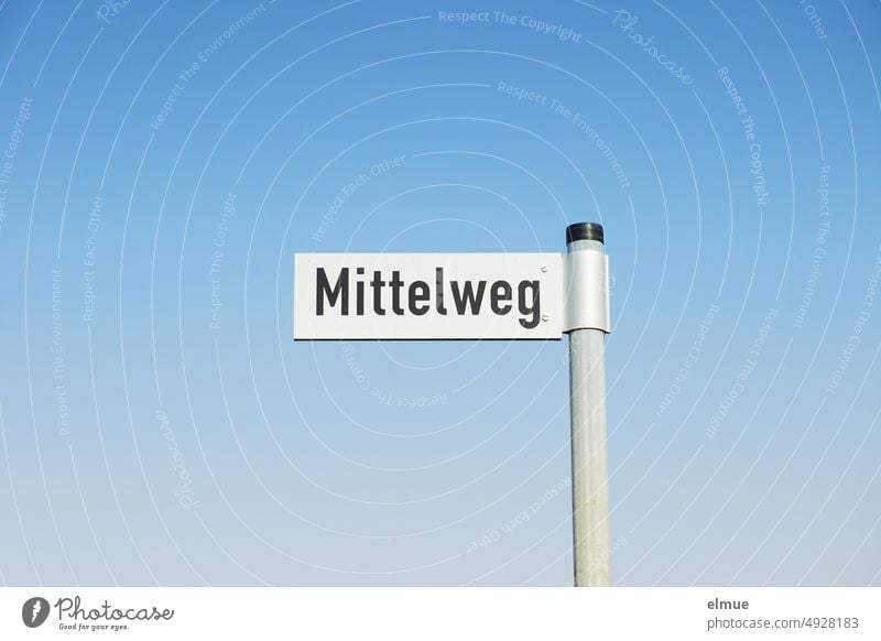 weißes Straßennamenschild mit schwarzer Schrift - Mittelweg - an einer Metallstange vor einem wolkenlosen blauen Himmel / wohnen Straßenschild himmelblau