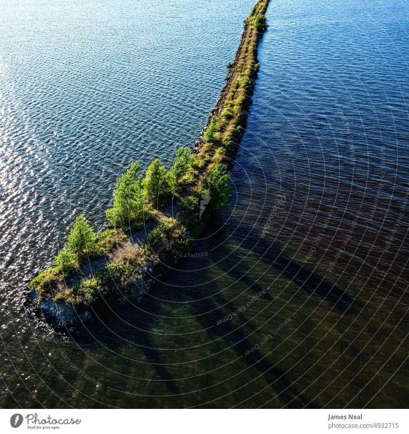 Die Sonne scheint hell über das Ende des Wellenbrechers am Lake Butte des Morts in Oshkosh, Wisconsin Uferlinie sonnig Fuchsenbach zerklüftet Natur Wasser Tag