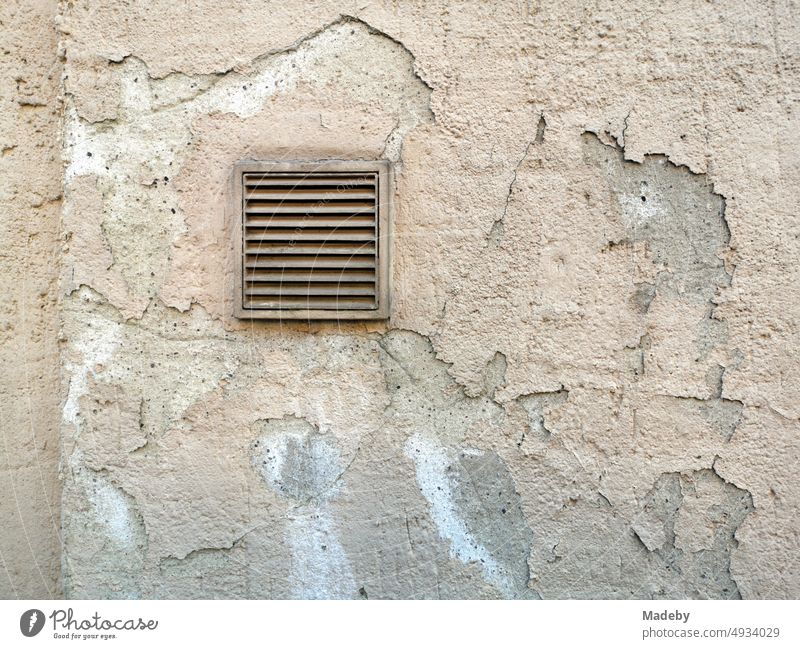 Quadratisches Lüftungsgitter in einer bröckelnden Fassade in Naturfarben in der Altstadt von Oerlinghausen bei Bielefeld im Teutoburger Wald in Ostwestfalen-Lippe