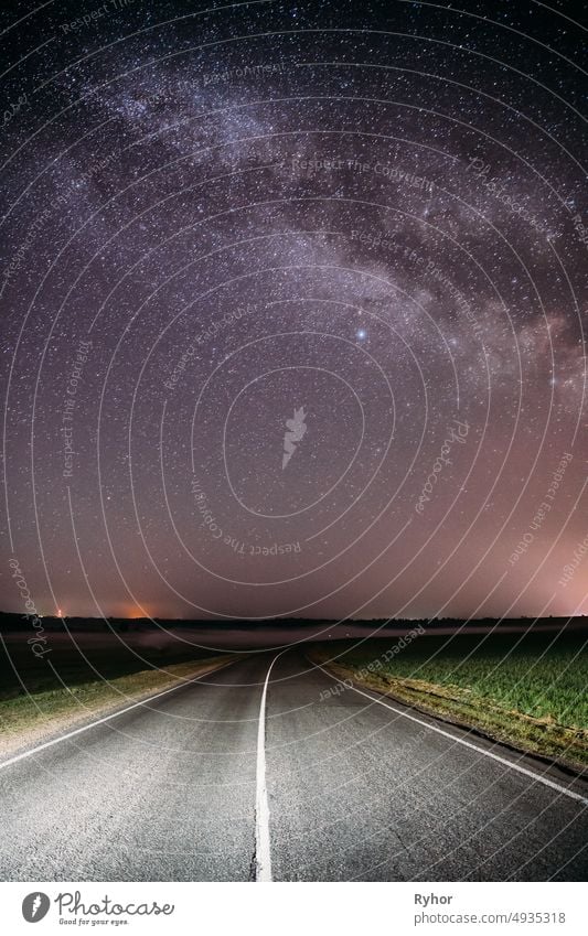 Nacht Sternenhimmel über Land Asphaltstraße in der Landschaft und grünes Feld. Nacht Ansicht der natürlichen glühenden Sterne und Milchstraße Galaxie