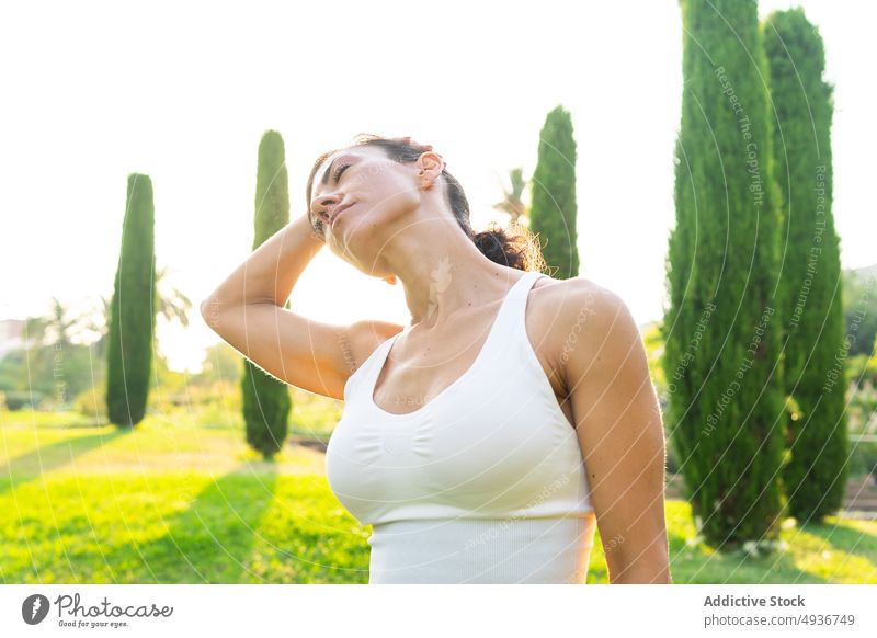 Aktive Frau beim Aufwärmen in der Natur Training Dehnung Sport Landschaft Übung Fitness Aktivität üben Gesunder Lebensstil Sonnenlicht Ausdauer Gras Vitalität