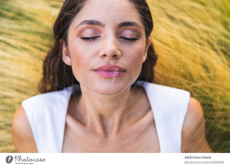 Ruhige Dame auf trockener Wiese liegend mit geschlossenen Augen Frau Lügen Gras Augen geschlossen Landschaft Anmut Model Windstille trocknen ruhig friedlich