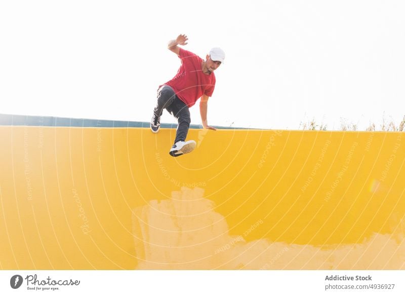 Energetischer Mann, der von einem Gebäude springt und einen Parkour-Stunt zeigt Le Parkour Trick springen Saum Energie Hipster Großstadt männlich extrem urban