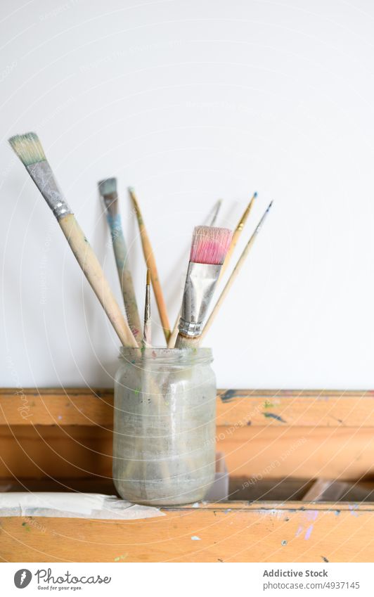 Gefäß mit Pinseln auf Staffelei Glas Pinselblume Papier Werkstatt Kunst blanko kreativ Handwerk Hobby dreckig Kulisse Inspiration Vorrat Schot Arbeitsplatz