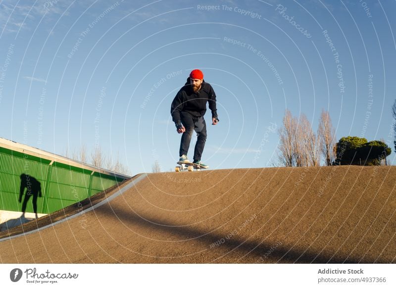 Mann fährt Skateboard auf Pumptrack Skateplatz Pumpe Bahn Mitfahrgelegenheit Skater Hipster Hobby Aktivität männlich Energie Bewegung cool Vollbart Erholung