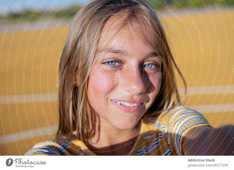 Lächelndes Mädchen nimmt Selfie auf der Straße Teenager Selbstportrait Fotografie Großstadt soziale Netzwerke Glück Kind heiter positiv Spielplatz Optimist froh