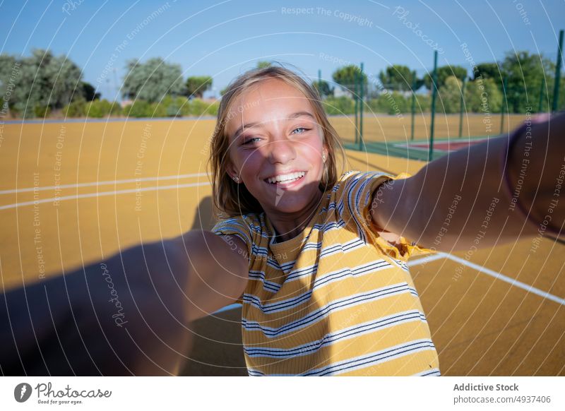 Lächelndes Mädchen nimmt Selfie auf der Straße Teenager Selbstportrait Fotografie Großstadt soziale Netzwerke Glück Kind heiter positiv Spielplatz Optimist froh