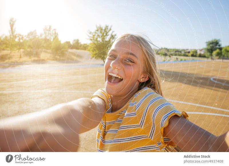 Lächelndes Mädchen nimmt Selfie auf der Straße Teenager Selbstportrait Fotografie Großstadt soziale Netzwerke Glück Kind heiter positiv Spielplatz Optimist froh