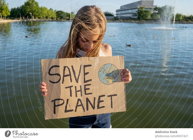 Mädchen mit Save The Planet-Schild in der Nähe des Flusses den Planeten retten Wasser Straße Aktivist Ökologie Aufmerksamkeit Problematik Krise Teenager