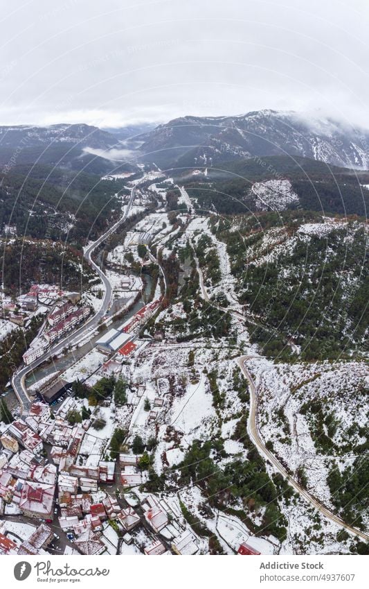 Malerische Berglandschaft mit schneebedeckten Hängen und schmalem Fluss Berge u. Gebirge Winter Straße Tal Schnee Kamm Nebel Landschaft Hochland malerisch eng