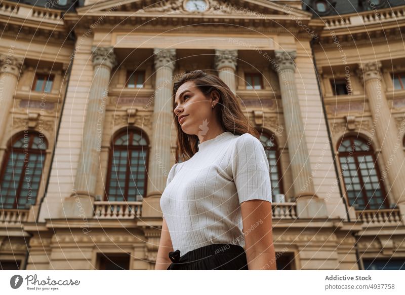 Ruhige junge Frau beim Sightseeing im alten Stadtviertel Ausflug Tourist Architektur Gebäude reisen Fassade Großstadt Reisender antik Außenseite brünett lässig