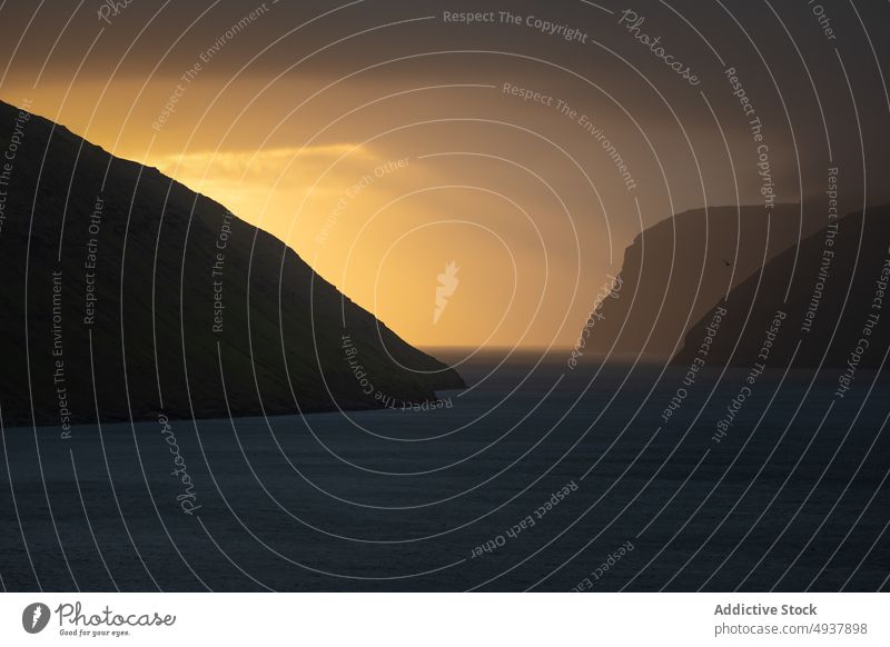 Meerwasser und Klippen vor orangefarbenem Himmel bei Sonnenaufgang MEER früh wolkig Rippeln Wasser Morgen Wetter Färöer-Inseln atemberaubend Morgendämmerung