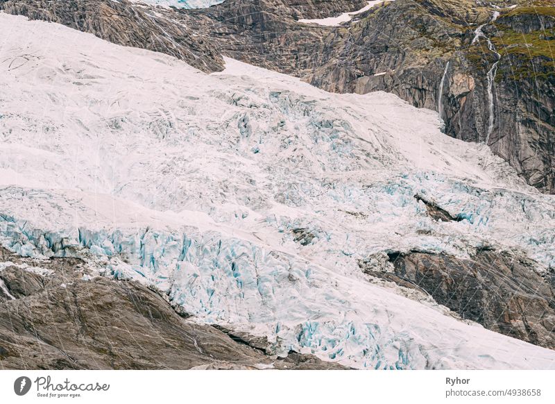 Jostedalsbreen National Park, Norwegen. Close Up View of Melting Ice and Snow, Small Waterfall On Boyabreen Glacier In Spring Sunny Day. Berühmtes norwegisches Wahrzeichen und beliebtes Reiseziel. Nahaufnahme