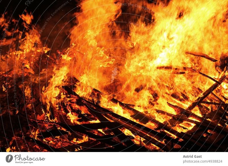 Stark brennendes Holz in der Nacht feuer brand hausbrand feuerbrunst funkenfeuer flammen funkenflug fegefeuer hölle osterfeuer glühen glut hitze holz wald