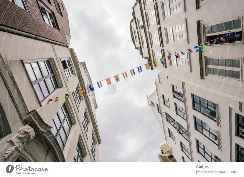 zwei Häuserfronten sind durch eine Leine mit verschiedenen Flaggen verbunden Europa Architektur Fahne Himmel Stadt Gebäude blau Haus Politik & Staat