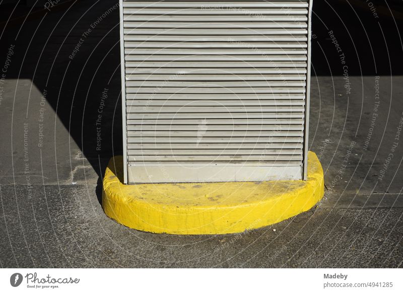 Lüftungsgitter auf einem leuchtend gelben Sockel im Sonnenschein an der Einfahrt eines Parkhaus in der Innenstadt von Frankfurt am Main in Hessen parkplatz