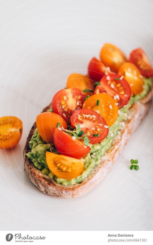 Toast mit Kirschtomaten und Avocado Zuprosten gestampft cucucmber Avocado-Toast Brot Mikro-Grün Mittagessen Frühstück frisch Lebensmittel Vegetarier Gesundheit