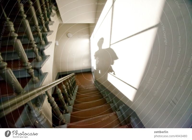 Schatten auf der Treppe absatz abstieg abwärts altbau aufstieg aufwärts fenster geländer haus mehrfamilienhaus menschenleer mietshaus stufe textfreiraum treppe