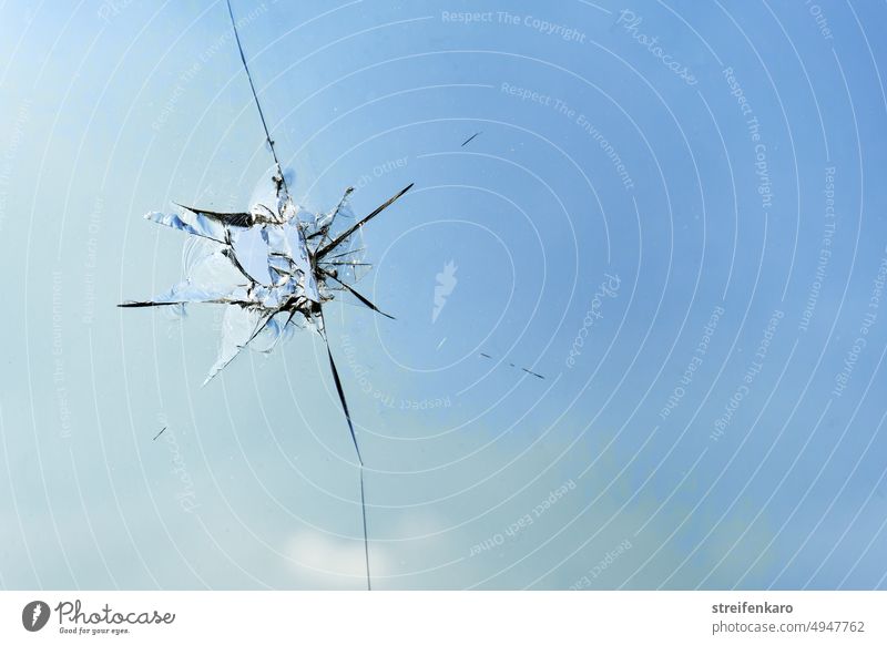 Zersprungener Himmel Loch Riss Steinschlag Scheibe Glasscheibe Fenster Fensterscheibe Hmmel Wolken blau kaputt zerstören beschädigen Gewalt Vandalismus