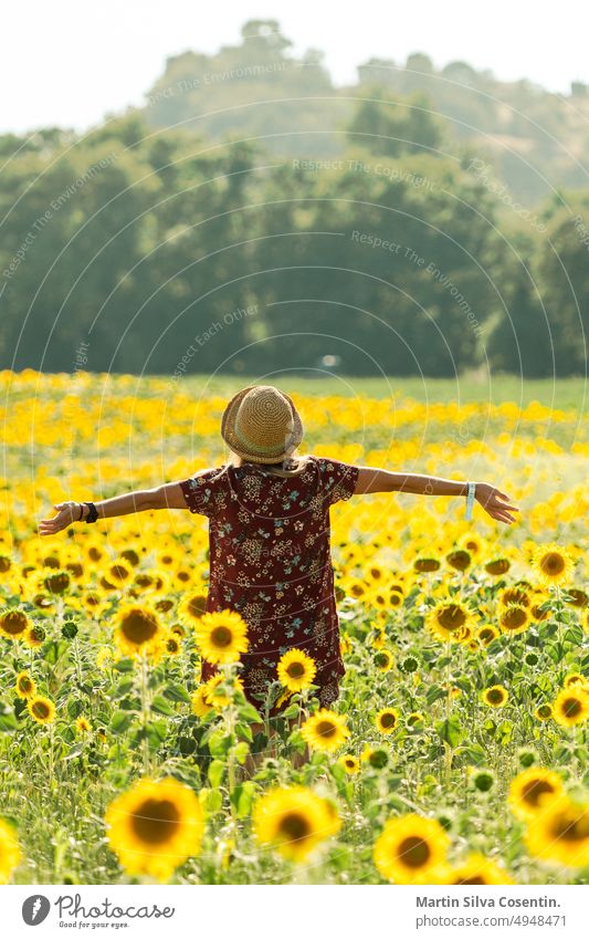 Eine Frau inmitten von Sonnenblumen genießt die schöne Nachmittagssonne. abstrakt Ackerbau Hintergründe Überstrahlung Blüte verschwommener Hintergrund hell