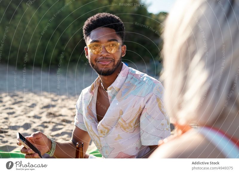 Verschiedene Freunde benutzen Smartphone am Strand benutzend teilen MEER Zusammensein Nachrichten blättern Wochenende Mann Frau Sommer jung vielfältig