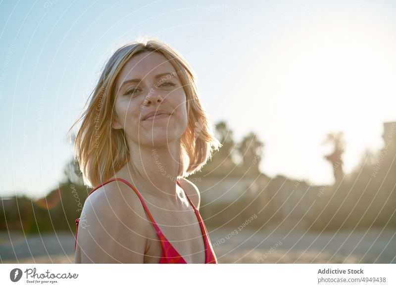 Glückliche Frau verbringt Zeit am Strand Sonnenlicht Wochenende Sommer Lächeln Resort Morgen Porträt heiter tagsüber Erholung froh positiv Badebekleidung blond