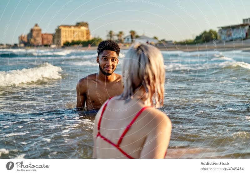 Verschiedener Mann und Frau im wogenden Meer Freundin MEER winken Zusammensein Strand Sommer Urlaub Wochenende Wasser Paar tagsüber Liebe schäumen Partnerschaft