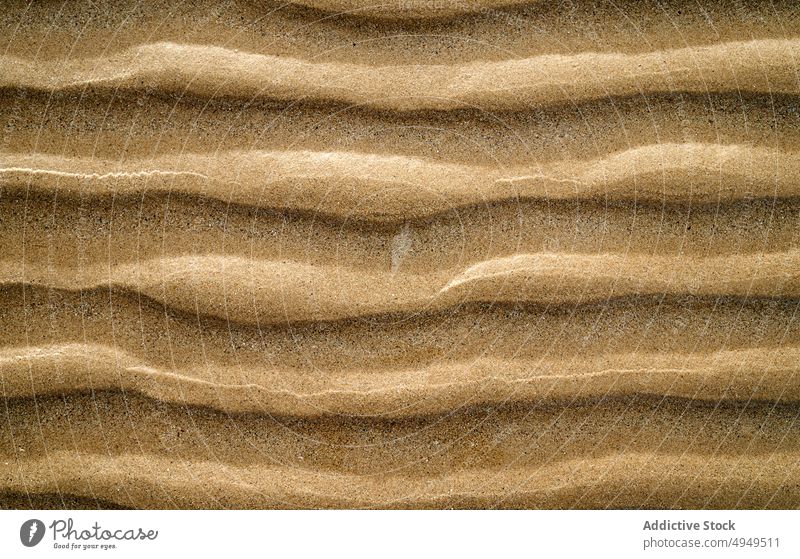 Gekräuselte Oberfläche von trockenem Sand Rippeln trocknen Textur Strand Sommer uneben rau Hintergrund Ufer winken Seeküste wüst Klima Dürre braun unfruchtbar