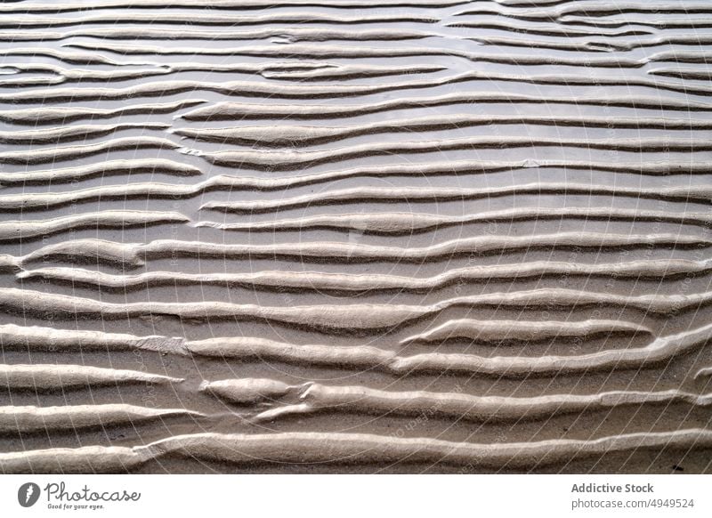 Gekräuselte Oberfläche von trockenem Sand Rippeln trocknen Textur Strand Sommer uneben rau Hintergrund Ufer winken Seeküste wüst Klima Dürre braun unfruchtbar