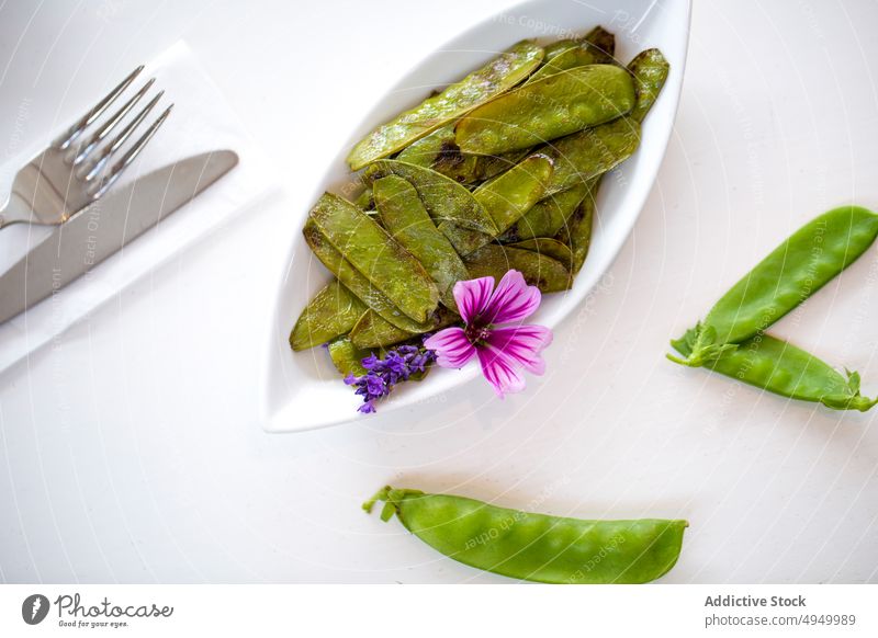 Gegrillte Zuckerschoten mit Blumen Zuckererbse Braten Teller Mittagessen dienen Garnierung Tisch Veganer Silberwaren Speise frisch Ernährung gesunde Ernährung