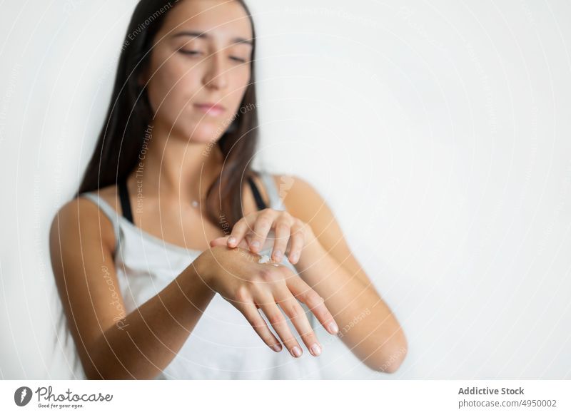 Junge Frau schmiert Creme auf die Hand Aufstrich Sahne Hautpflege Schönheitsprogramm Sauberkeit Spa Kosmetik Produkt Leckerbissen jung brünett perfekt Hygiene