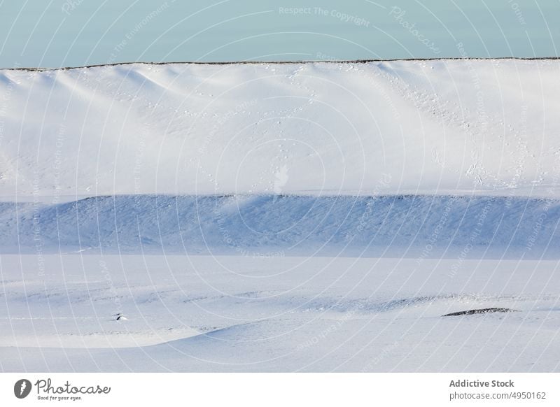 Straße in der Nähe eines verschneiten Berges im Winter Hügel Schnee Berge u. Gebirge wolkig Himmel gerade kalt Natur Island atemberaubend Landschaft Kamm