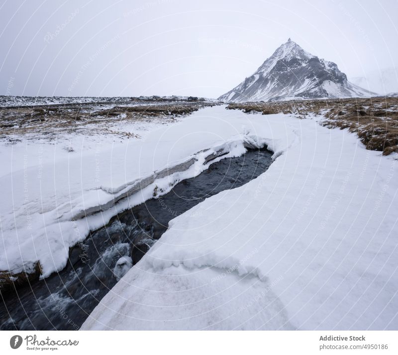 Fluss in der Nähe des Berges im Winter Berge u. Gebirge Tal Schnee kalt grau Himmel Wasser Wetter Island Landschaft Natur Saison Eis strömen Klima polar