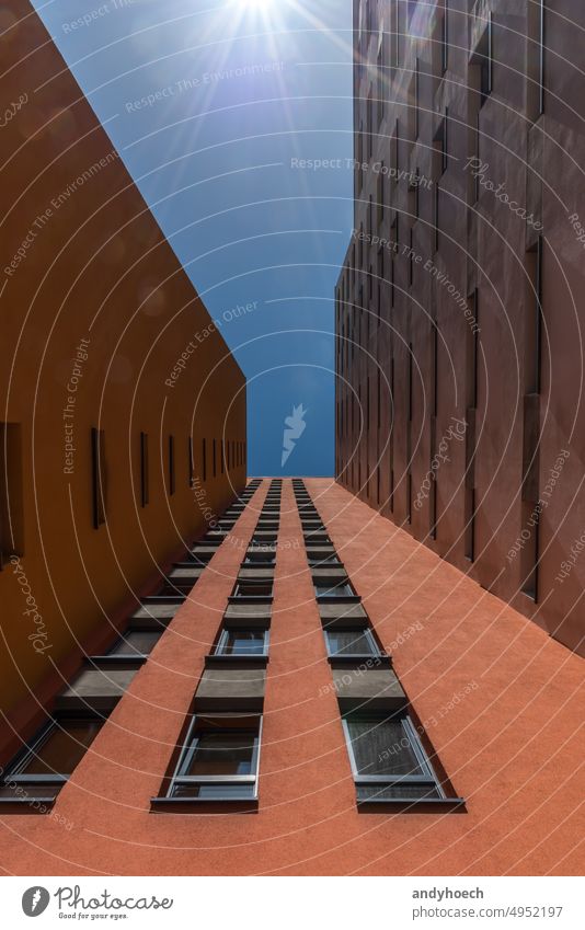 Roter Wolkenkratzer in klaren Formen in der Ansicht von unten im Sommer Architektur Berlin blau Gebäude Großstadt Stadtbild übersichtlich Klarer Himmel Design