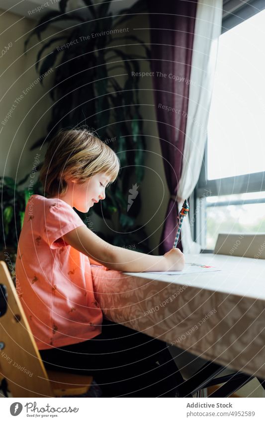 Niedliches kleines Mädchen bei den Hausaufgaben Kind schreibend Bildung im Innenbereich sitzen allein Aufmerksamkeit schön Schlafzimmer Buch lässig Kaukasier