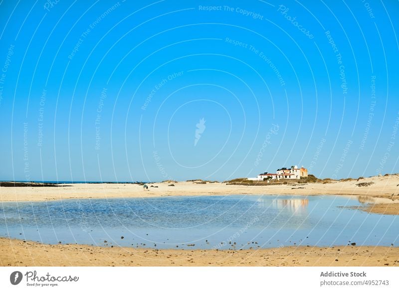 Sandstrand gegen Meer unter blauem Himmel MEER Blauer Himmel Natur Gebäude Landschaft Route Architektur Strand Ufer Insel Horizont sandig braun Farbe Haus