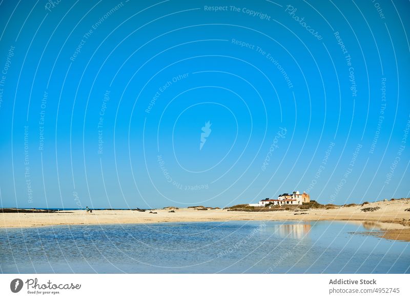 Sandstrand gegen Meer unter blauem Himmel MEER Blauer Himmel Natur Gebäude Landschaft Route Architektur Strand Ufer Insel Horizont sandig braun Farbe Haus