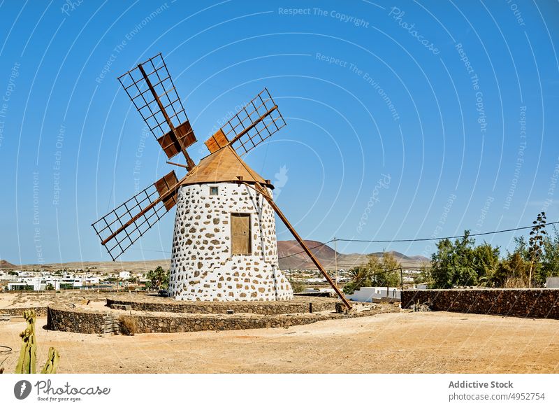 Alte Windmühle auf Steinplattform unter blauem Himmel Turm Energie Kraft Motor Natur alternativ produzieren Blauer Himmel Insel Rotation Konstruktion Mühle