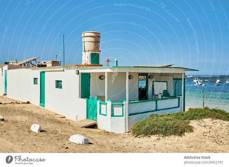 Bauwerk mit Leuchtturm am Meeresufer im Sonnenlicht Konstruktion Architektur nautisch Verkehr Blauer Himmel Natur vegetieren Insel Stein Leuchtfeuer wolkig