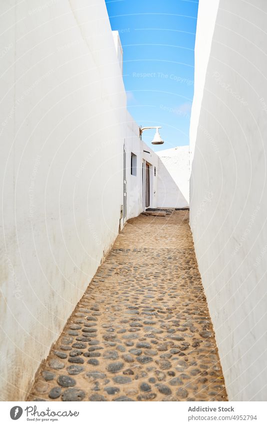 Enge Passage zwischen weißen Häusern unter blauem Himmel Durchgang Kopfsteinpflaster Haus eng Gebäude Architektur ländlich Weg Laufsteg Fassade Außenseite