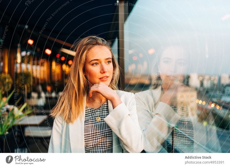 Verträumte Frau in einem abendlichen Dachrestaurant Dachterrasse Restaurant verträumt Café Abend Sonnenlicht genießen nachdenklich Kälte Stil