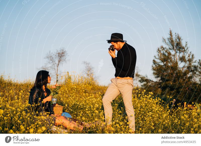 Freund fotografiert seine Freundin auf einem Feld Fotograf fotografieren Fotoapparat Gedächtnis Moment professionell Frau Großstadt benutzend Gerät modern Stil