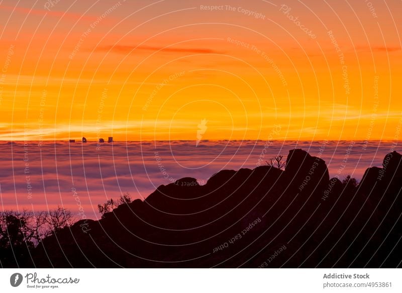 Silhouette von modernen Gebäuden zwischen Wolken bei Sonnenaufgang Sonnenuntergang Felsen Berge u. Gebirge Himmel hoch Natur aktiv extrem Nebel Klippe Top