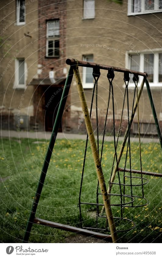 Schaukel Spielzeug Spielplatz Hof Hinterhof Garten Wiese Rasen alt kaputt trist Rost Fassade Haus Wohnhaus Putz Fenster Tag Außenaufnahme Menschenleer